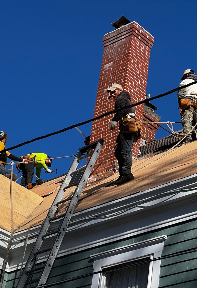 Crew replacing an old stale roof with modern materials
